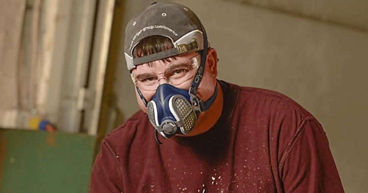 Worker wearing a GVS Malaysia respirator for protection in an industrial setting.